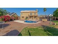 Expansive backyard featuring a pool, desert landscaping, outdoor kitchen and beautiful home at 2022 N 124Th Dr, Avondale, AZ 85392