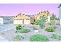 Inviting single-story home featuring a three-car garage, desert landscaping and solar panels at 329 S Marin Dr, Gilbert, AZ 85296