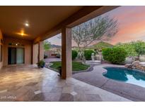 Spacious covered patio with travertine flooring, offering scenic backyard views at 41715 N River Bend Rd, Phoenix, AZ 85086