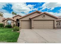 Charming single-story home with a three car garage, tile roof and manicured front lawn at 4620 E Desert Cactus St, Phoenix, AZ 85032