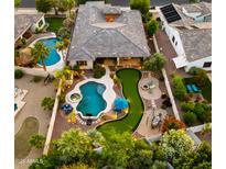 Stunning aerial view of a private backyard oasis featuring a pool, putting green, and outdoor entertaining area at 4865 S Cylinder Way, Mesa, AZ 85212