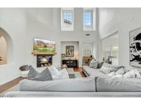 Bright living room with high ceilings, fireplace, large couch and clerestory windows providing natural light at 9433 E Trailside Vw, Scottsdale, AZ 85255