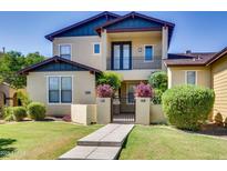 Inviting two-story home featuring lush landscaping, a gated courtyard, and a private second-story balcony at 15387 W Columbine Dr, Surprise, AZ 85379