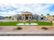 Stunning home featuring a circular driveway, portico entry, and lush green lawn with custom landscaping at 16368 W Watkins St, Goodyear, AZ 85338