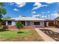 Charming single-story home with a well-manicured lawn, brick accents, and a covered carport at 2122 W Piccadilly Rd, Phoenix, AZ 85015