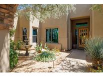 Inviting home exterior with a fountain, desert landscaping, and beautiful natural lighting around the property entrance at 28045 N 112Th Pl, Scottsdale, AZ 85262
