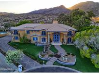 Elegant two-story home with a well-manicured lawn, water feature, and mountain views at 12240 S Honah Lee Ct, Phoenix, AZ 85044