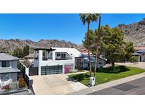 Modern two-story home with a metal roof, 3-car garage, palm trees and a mountain backdrop at 2308 E State Ave, Phoenix, AZ 85020