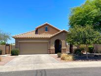 Charming single-Gathering home featuring a two-car garage, tile roof, and desert landscaping at 6557 S Classic Way, Gilbert, AZ 85298