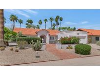 Charming Southwestern home features a red tile roof, lush landscaping, and a welcoming brick pathway at 8666 E Cheryl Dr, Scottsdale, AZ 85258