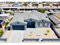 Charming light blue home with a large driveway and landscaped front yard, showcasing neighborhood views at 32101 W Palo Verde St, Wittmann, AZ 85361