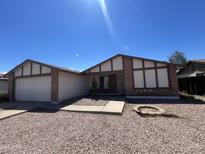 Single-story home with brick accents, a two-car garage, and desert landscaping at 6225 W Zoe Ella Way, Glendale, AZ 85306