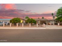Charming single story home featuring an enclosed front yard, mature trees, and covered carport at 7423 E Cambridge Ave, Scottsdale, AZ 85257