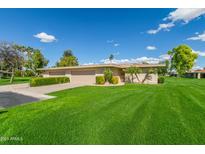 Charming single-story home with a well-manicured lawn and low maintenance desert landscaping at 7646 E Miami Rd, Scottsdale, AZ 85258