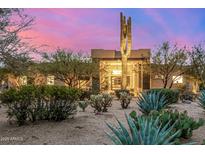 Desert home at sunset featuring lush desert landscaping, mature trees, and a grand entrance at 9627 E Adobe Dr, Scottsdale, AZ 85255
