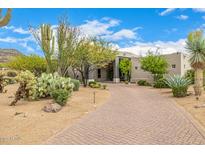 Expansive desert home with a meticulously designed driveway and lush native landscaping at 9627 E Adobe Dr, Scottsdale, AZ 85255