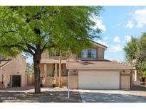 Charming two-story home featuring a well-maintained front yard, covered entryway, and attached two-car garage at 991 W Leah Ln, Gilbert, AZ 85233