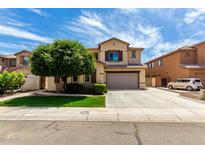 Two-story home featuring desert landscaping, two-car garage, and neutral color scheme under a bright blue sky at 13259 W Flower St, Litchfield Park, AZ 85340