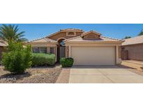 Charming single-story home with a well-maintained front yard, desert landscaping, and a two-car garage at 13421 W Ocotillo Ln, Surprise, AZ 85374