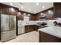 Modern kitchen features stainless steel appliances, dark cabinetry, and bright, tiled backsplash at 15380 N 100Th St # 1124, Scottsdale, AZ 85260