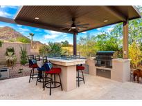 Outdoor kitchen and bar area with mountain views and seating at 16201 S 29Th Ave, Phoenix, AZ 85045