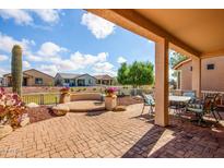 Inviting covered patio featuring brick pavers, a built-in bench, and a peaceful outdoor seating area at 20455 N Lemon Drop Dr, Maricopa, AZ 85138