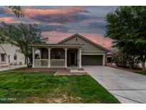 Beautiful single-story home showcasing a delightful front porch under a colorful dusk sky at 20866 W Hamilton St, Buckeye, AZ 85396