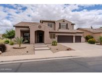 A charming two-story home featuring a three-car garage, a well-manicured front yard, and an inviting entrance at 3053 S Canfield --, Mesa, AZ 85212