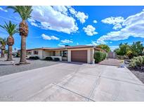 Charming single-story home boasts a well-manicured yard and attached two-car garage at 6041 E Colby St, Mesa, AZ 85205