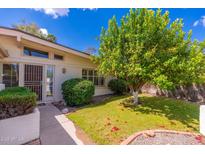 Charming home exterior with lush green lawn, mature tree, and inviting walkway at 617 W Gibraltar Ln, Phoenix, AZ 85023