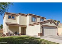 Charming two-story home featuring a well-maintained lawn and two-car garage at 12430 W Scotts Dr, El Mirage, AZ 85335