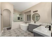 Beautiful bathroom with a soaking tub, walk-in shower, dual sink vanity, and decorative tile flooring at 16014 S 13Th Way, Phoenix, AZ 85048