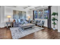 Bright living room featuring modern decor, plush seating, and an abundance of natural light through a large window at 16322 N 171St Dr, Surprise, AZ 85388