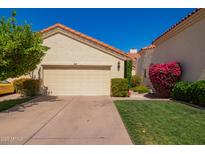 Charming home exterior featuring a two-car garage, terra cotta roof, and meticulously landscaped front yard at 1700 E Lakeside Dr # 64, Gilbert, AZ 85234