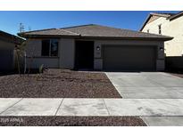 Charming single-story home with a well-manicured front yard and a two-car garage at 17482 W Fulton St, Goodyear, AZ 85338