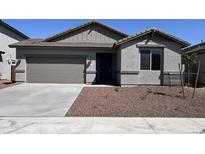 Charming single-story home featuring a neutral-toned exterior, a two-car garage, and low maintenance desert landscaping at 17488 W Fulton St, Goodyear, AZ 85338