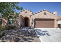 Charming home featuring a desert landscape, inviting front entrance, and two-car garage at 26725 W Marco Polo Rd, Buckeye, AZ 85396