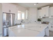 Bright kitchen with stainless steel appliances, large island, and white cabinetry at 43481 W Carefree Pl, Maricopa, AZ 85138