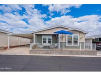 Charming single-story home featuring a covered porch, carport, and nicely landscaped front yard with a seating area at 650 N Hawes Rd # 4128, Mesa, AZ 85207