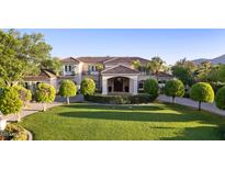 Elegant home showcasing a manicured lawn, tasteful landscaping, and a charming Mediterranean-style facade at 6997 E Paradise Ranch Rd, Paradise Valley, AZ 85253