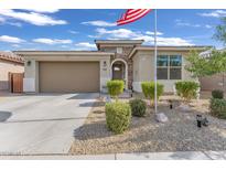 Charming single-story home featuring desert landscaping, stone accents, and an American flag in the front yard at 9343 W Atlantis Way, Tolleson, AZ 85353