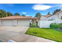Charming single-story home with a red tile roof, a well-manicured lawn, and two-car garage at 975 E Chilton Dr, Tempe, AZ 85283