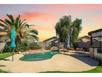Stunning pool features a waterfall, lush landscaping, and a serene atmosphere for outdoor relaxation and enjoyment at 14246 W Columbus Ave, Goodyear, AZ 85395