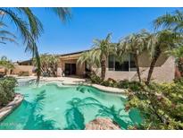 Inviting pool surrounded by palm trees and lush landscaping at 16753 W Bristol Ln, Surprise, AZ 85374