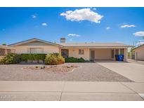 Charming single-story home with well-maintained landscaping and a covered carport at 6337 E Evergreen St, Mesa, AZ 85205