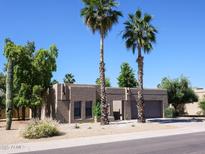 Inviting single-story home featuring palm trees, desert landscaping, and an attached two-car garage at 6721 E Phelps Rd, Scottsdale, AZ 85254