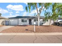 Charming single-story home with well-maintained landscaping and a classic design under a partly cloudy sky at 830 E Orchid Ln, Phoenix, AZ 85020