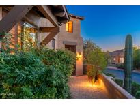 Inviting exterior showcasing a desert home with stone accents, lush landscaping, and a warm, welcoming ambiance at 9270 E Thompson Peak Pkwy # 367, Scottsdale, AZ 85255