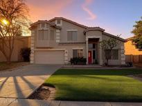 Charming two-story home with a well-manicured lawn and a red front door at 1342 N Mckenna Ln, Gilbert, AZ 85233