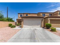 Tan two-story home with a two-car garage and desert landscaping at 2565 E Southern Ave # 130, Mesa, AZ 85204
